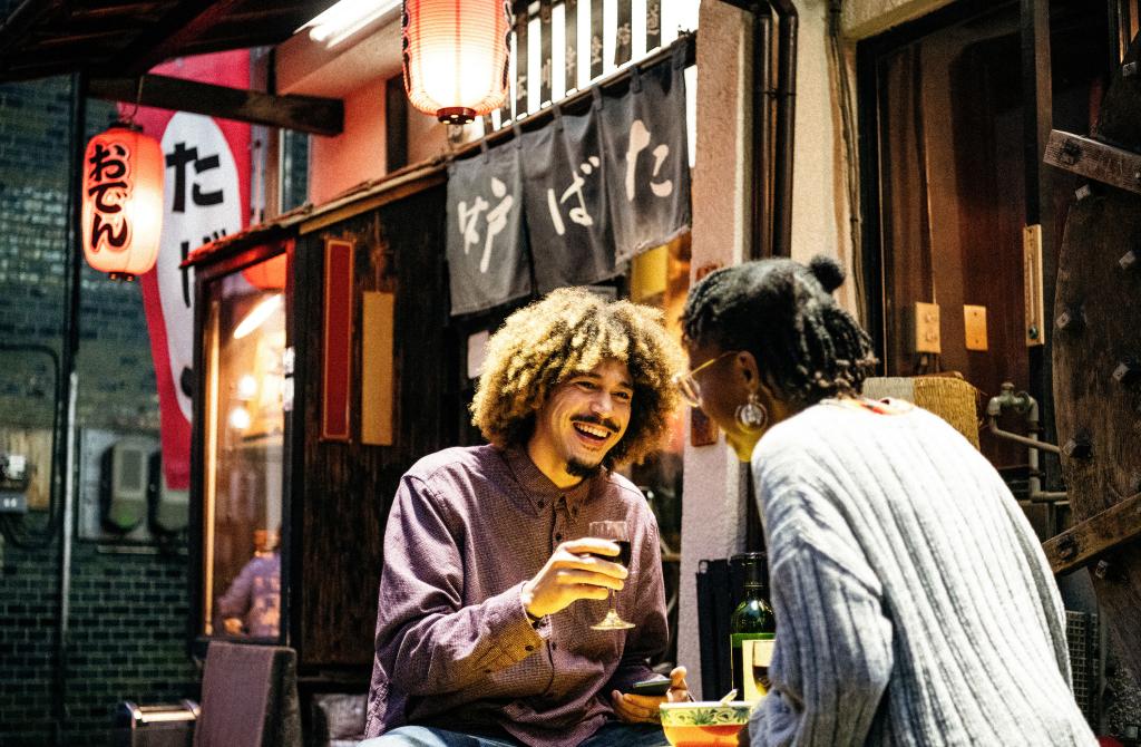 Two individuals drinking in a restaurant in Japan. 