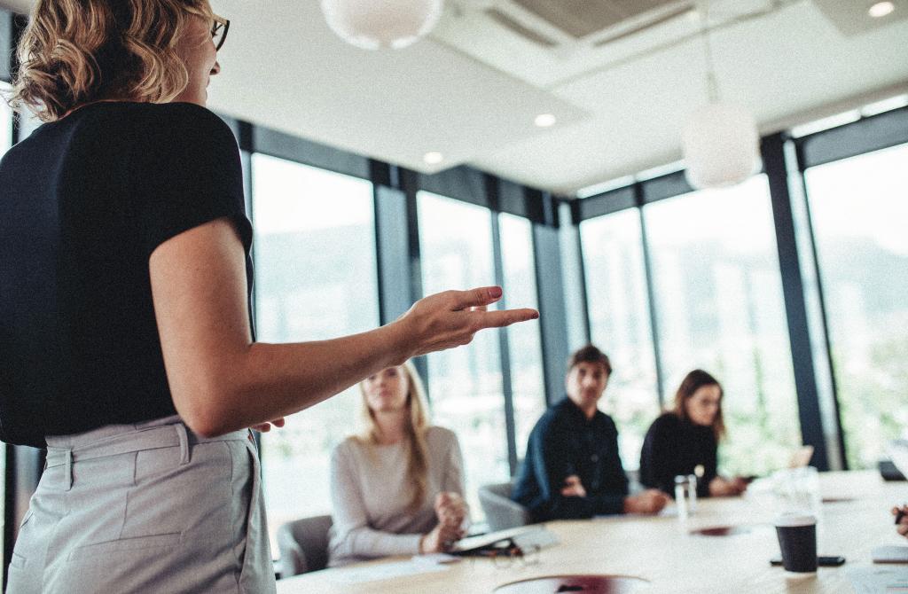 An individual giving a presentation in front of a group in an office.