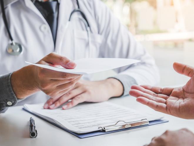 Physician handing prescription to patient  Physician handing prescription to patient