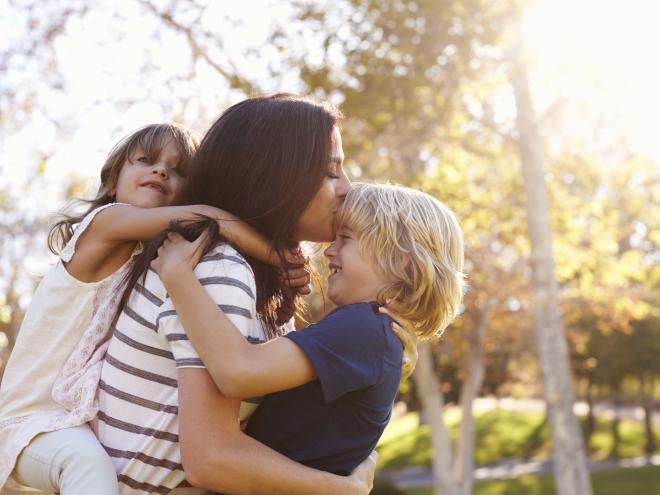 Mother holding her two children  Mother holding her two children