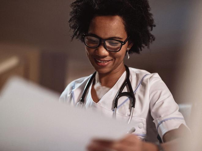 A doctor looking over paperwork and smiling.
