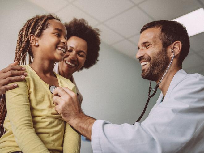 A doctors examines a young patient's heart