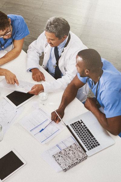 A group of doctors reviewing documents sitting at a table. 