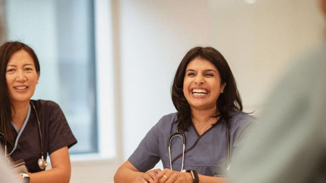 Doctor smiling in a group meeting.